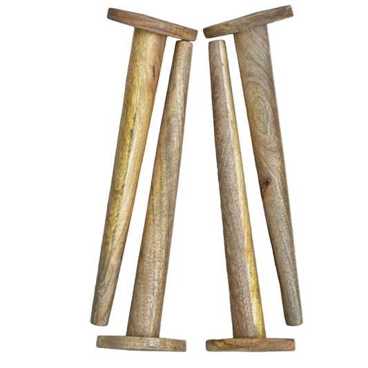 Four wooden table legs on a light wood background