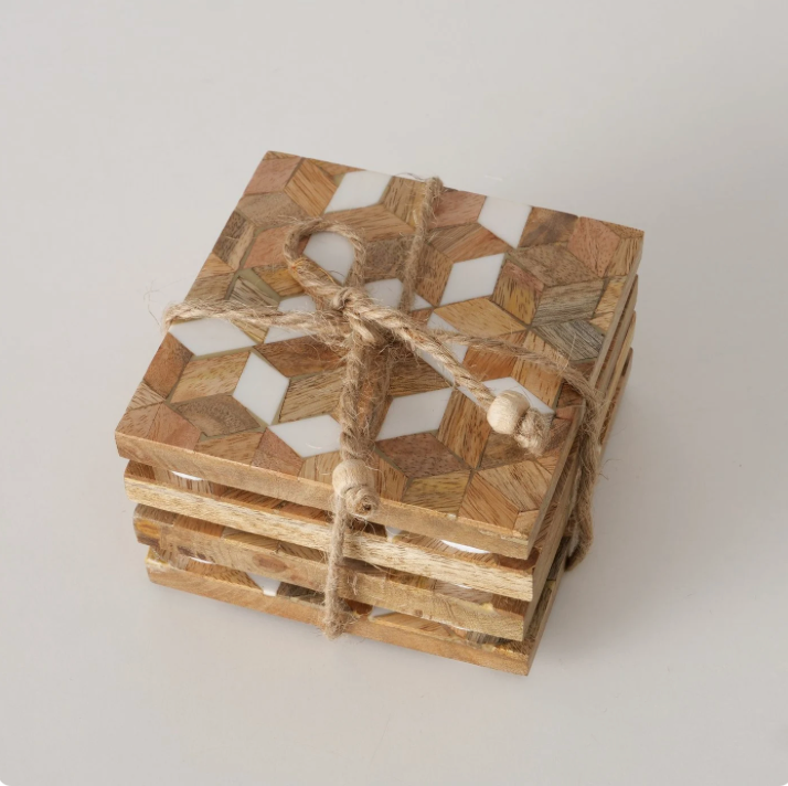 Stack of wooden coasters with geometric pattern on a light gray background