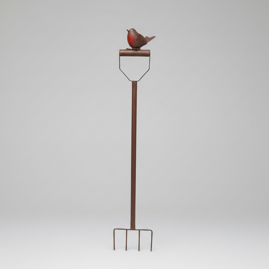Decorative metal bird on a stake against a white brick wall.