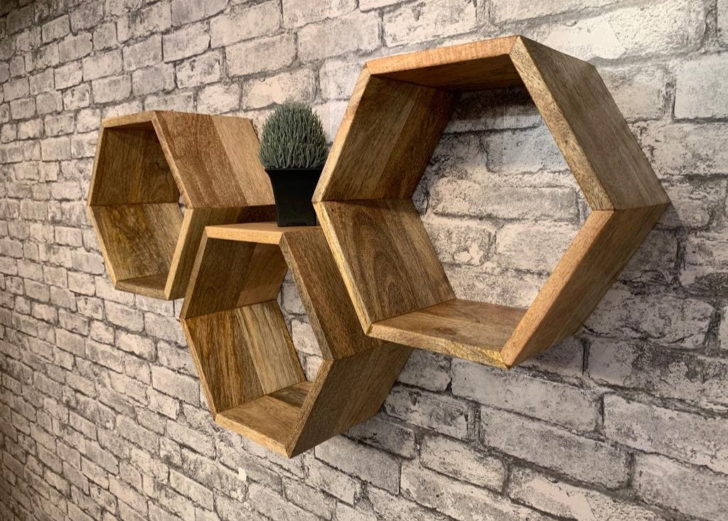 Hexagonal Mango wood floating wall shelves mounted on grey brick wall. 