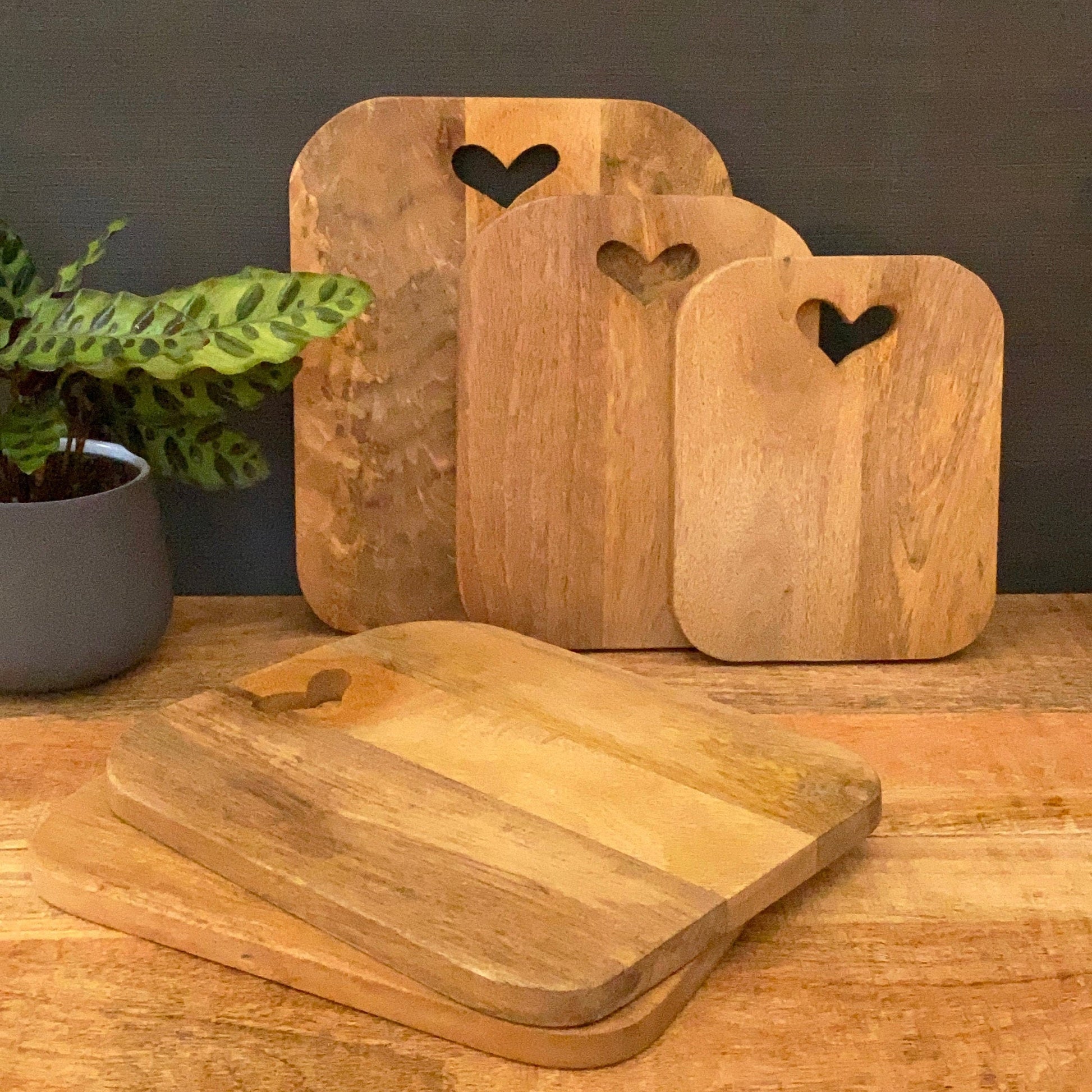 Mango wood chopping boards with cut out heart on a table