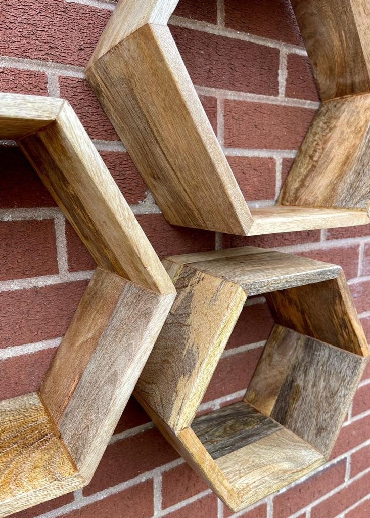 Hexagonal Mango wood floating wall shelves mounted on brick wall. 