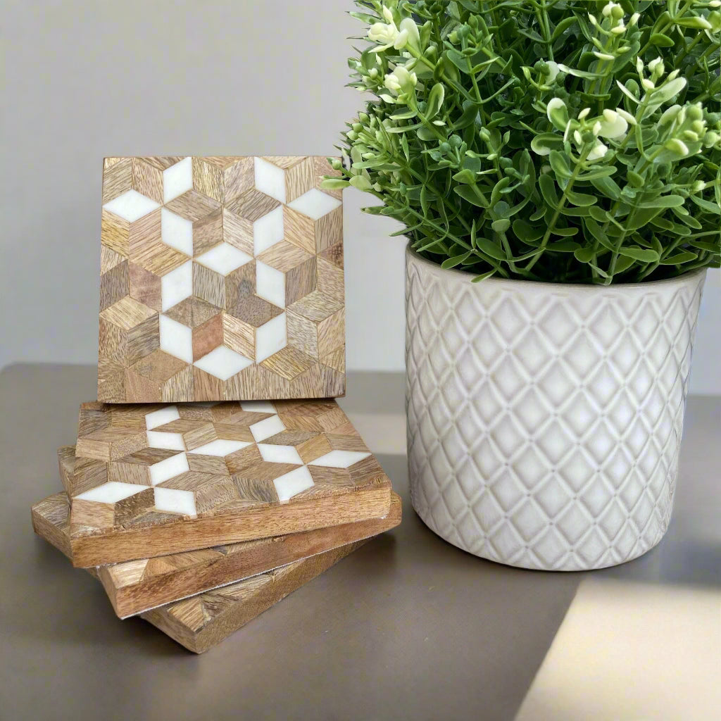 Mosaic Mango wood square coasters with resin inlay. 4 coasters next to plant.