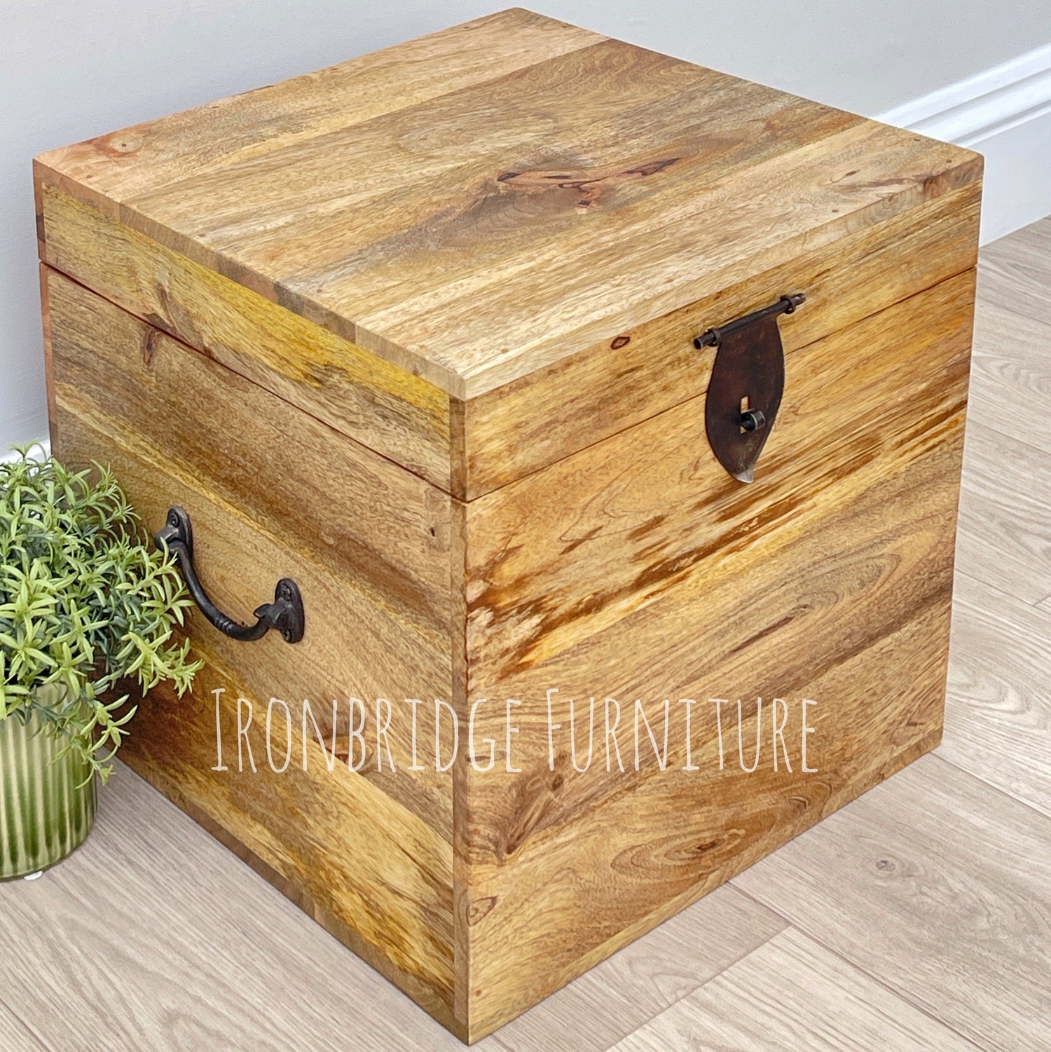 A square solid natural mango wood storage trunk with metal work handles used for vinyl record storage.