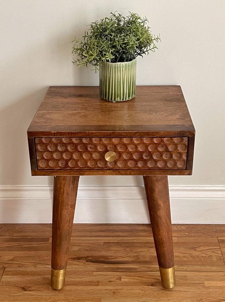 Dark Mango wood side table with 1 carved drawer and tapered legs. Straight on shot. 