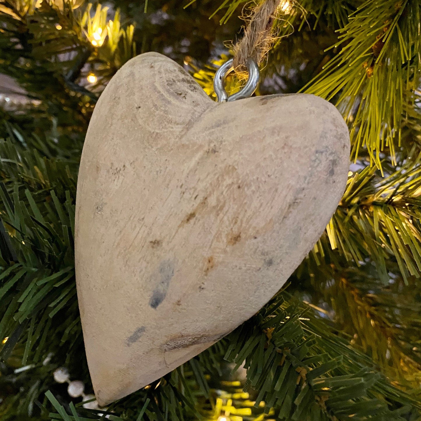 Hanging Mango wood carved heart on a chunky jute string. Close up