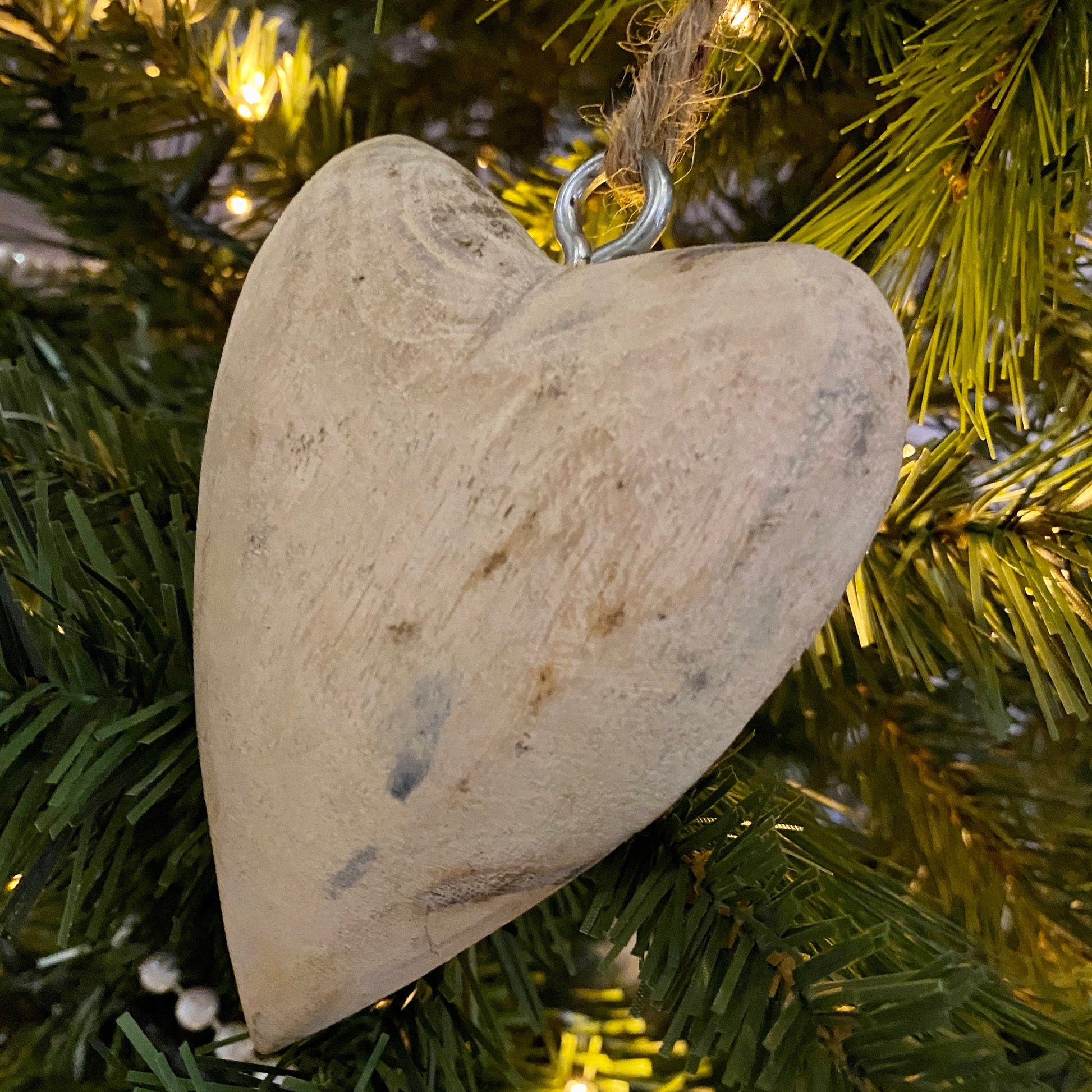 Hanging Mango wood carved heart on a chunky jute string. Close up