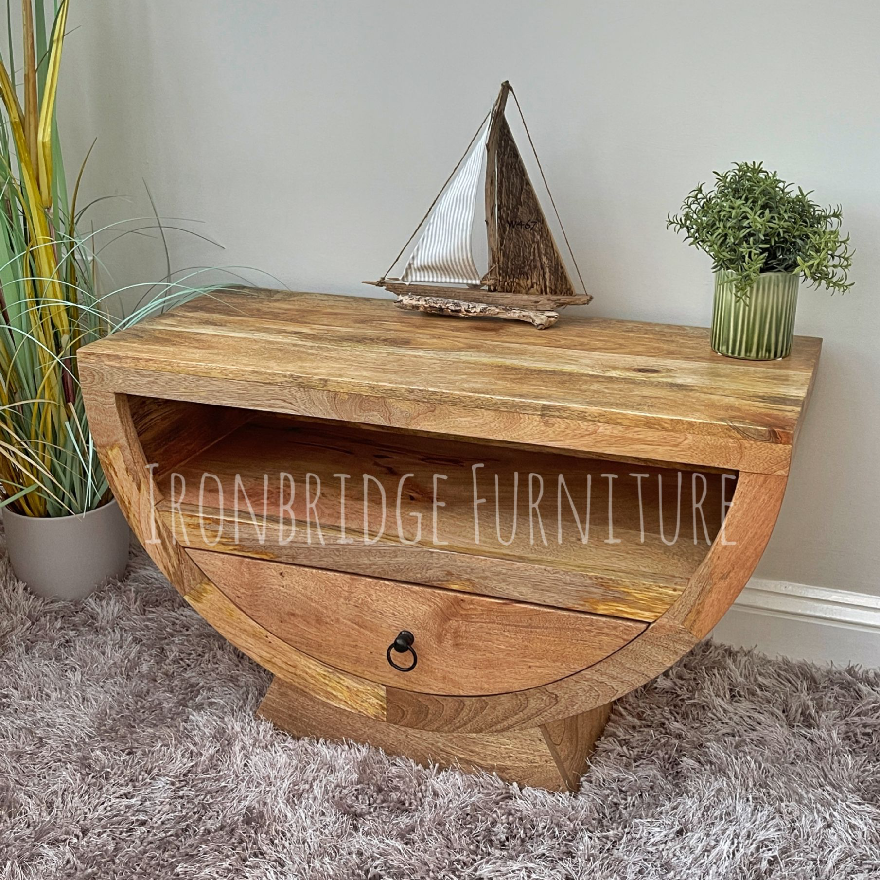 Mango wood half moon shaper TV small sideboard in a room setting at an angle