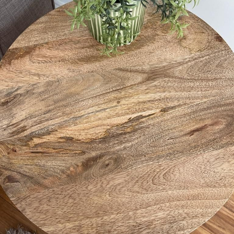 Round wooden table with a plant on top