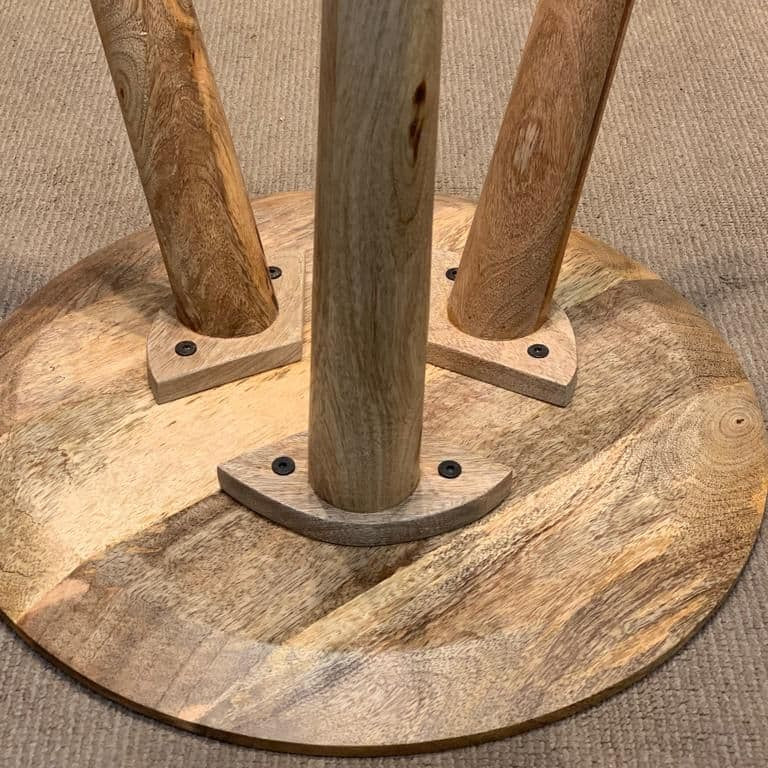 Wooden stand with three vertical posts on a textured surface