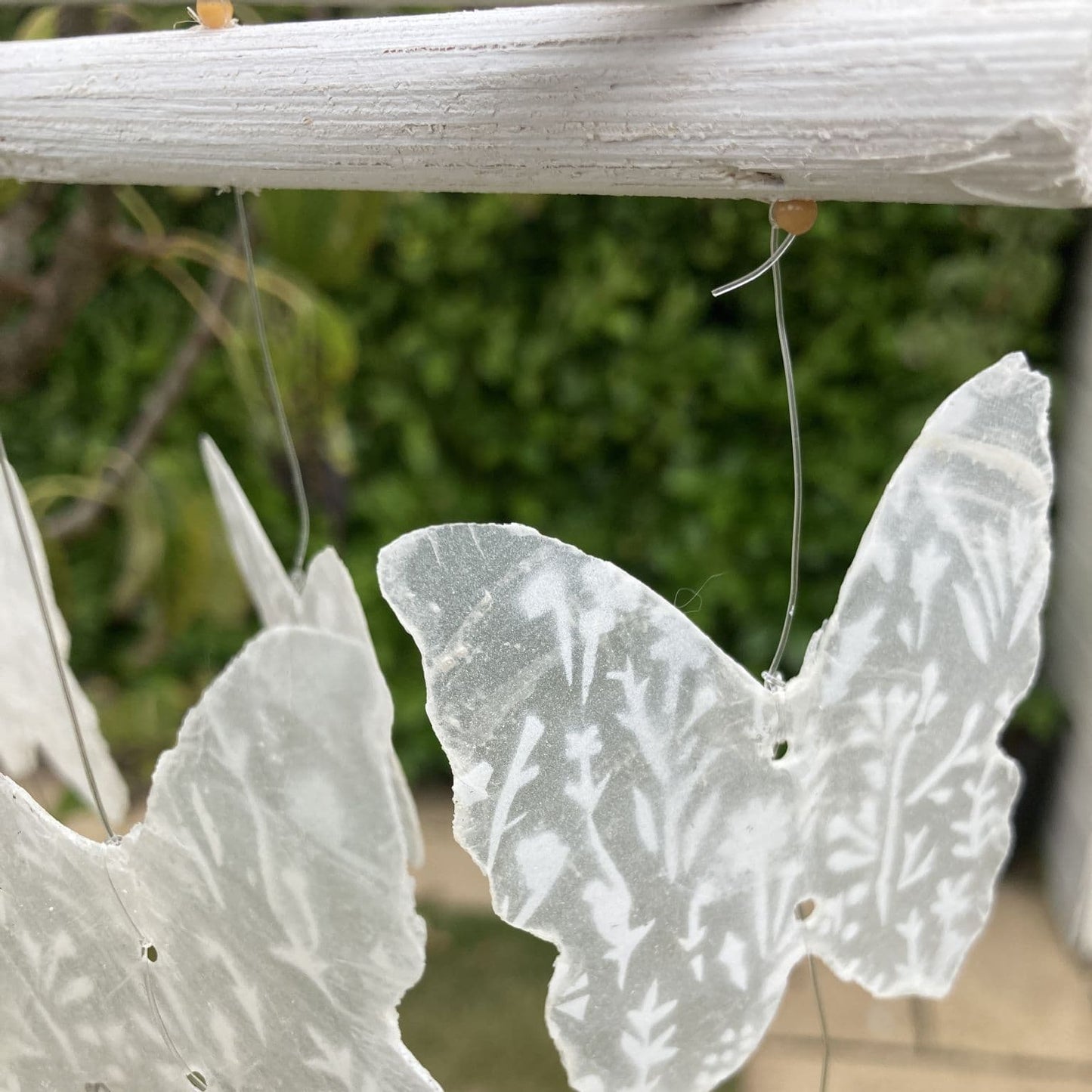 Natural Capiz shell wind chime Butterfly design - white. Close up of single butterfly. 
