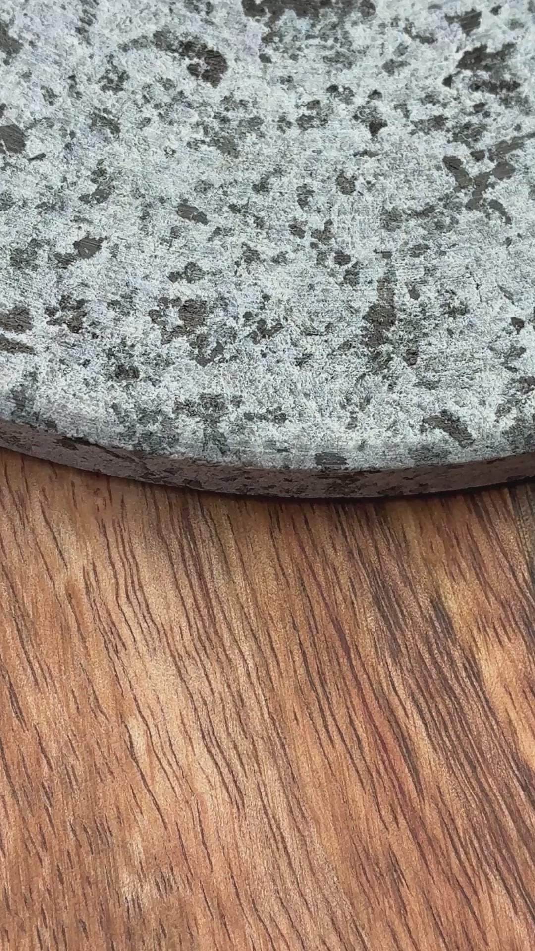 grey granite round trivet on wooden plank